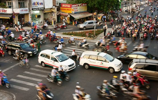HO CHI MINH CITY, VIET NAM- MAR 27: Vehicle motion blur in urban, group of person wear helmet transfer by motorcycle in chaotic, unsafe situation of town traffic, Sai Gon, Vietnam, Mar 27, 2014