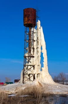 Water tower with ice and with  large icicle, Russia.