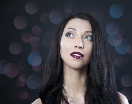 beautiful woman with blue eyes on a black background bokeh