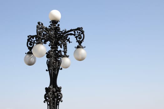 Ornate castle street lamp with blue sky background.