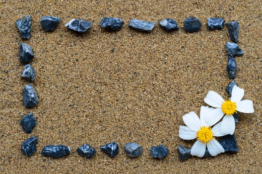 border frame with gravel and white flower on the beach