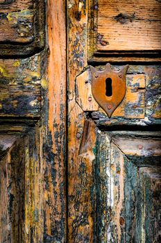 Detail of vintage key hole on weathered wooden door