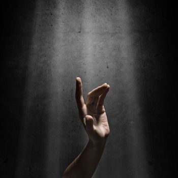 woman's hand reaches for the light rays, conceptual image of striving for freedom