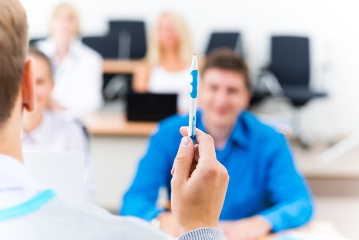 close-up of hands of a teacher with a ballpoint pen, the teacher focuses attention on himself gesture