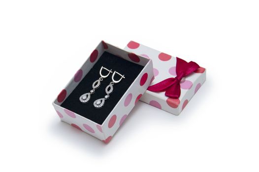 Silver earrings in a box on white background