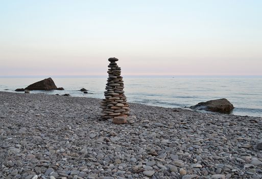 pyramid of stones on the beach during sunset