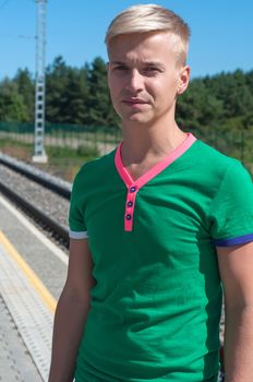 Shot of stylish man in green t-shirt standing on platform