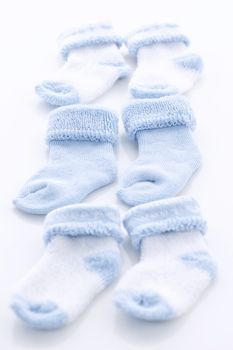 Arrangement of three pairs of blue infant boy socks for baby shower