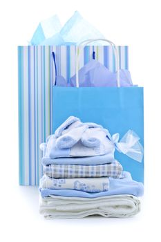 Gift bags and infant clothes for baby shower isolated on white