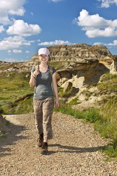 Smiling girl walking on path at the Badlands in Dinosaur provincial park, Alberta, Canada