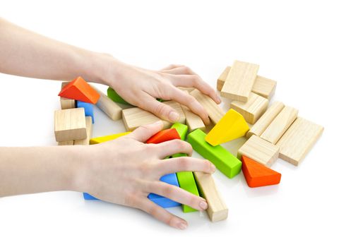 Hands with pile of wooden block toys isolated on white