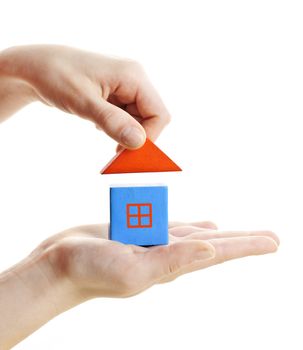 Hand building wooden block toy house isolated on white background