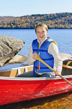 Teen girl canoeing on Lake of Two Rivers, Ontario, Canada