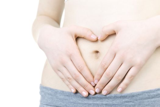 Woman showing heart shape with her hands on stomach