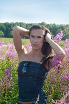 Outdoor shot of beautiful brunette female with long hair in field