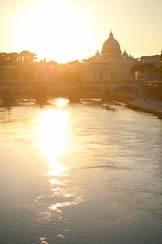 View of Tiber and St. Peter's cathedral at sunset in Rome