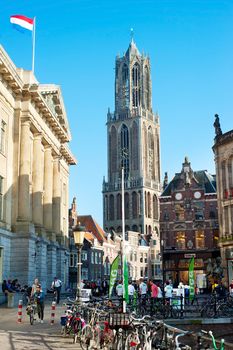 UTRECHT, NETHERLANDS - MARCH 03, 2014: People walking on the old town street, in front of the Dom Tower in  Utrecht. Utrecht's ancient city centre features many buildings and structures from the Early Middle Ages
