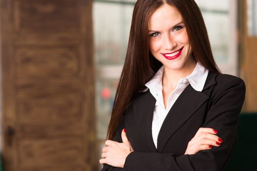 Beautiful young adult woman looks right at camera in the office