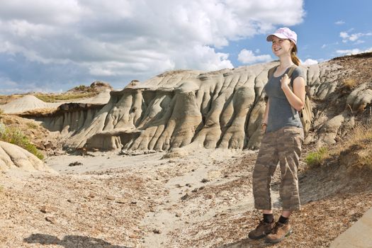 Smiling young girl standing at the Badlands in Dinosaur provincial park, Alberta, Canada