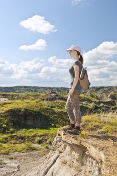 Happy female hiker looking onto the Badlands in Dinosaur provincial park, Alberta, Canada