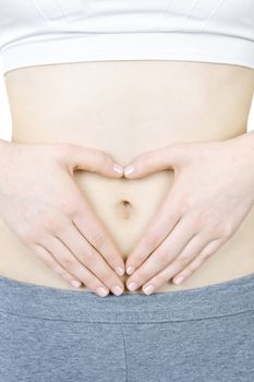 Woman showing heart shape with her hands on stomach