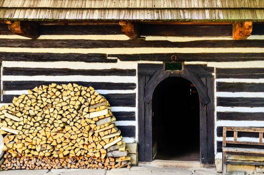 Entrance to traditional old cottage with pile of firewood, Slovakia