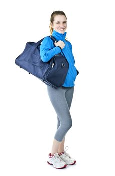 Happy fit young woman with gym bag standing ready for fitness exercise