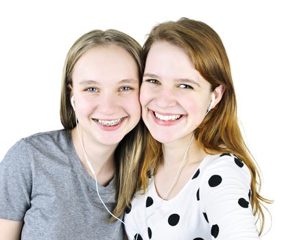 Portrait of two teenage girl friends listening to music sharing earphones