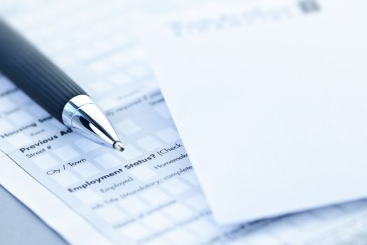 Blank credit application form with envelope and pen close up