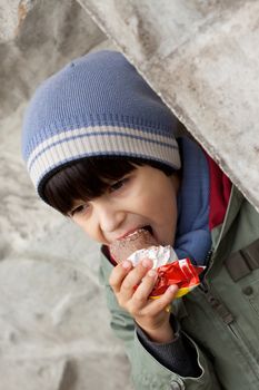 little boy in knitted cap eating ice cream