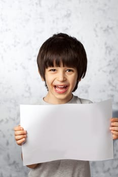 Laughing boy holding a white sheet for the label