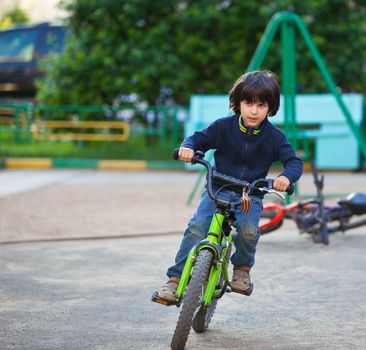 boy racing on a green bike