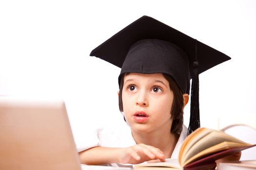 little boy in hat with computer and textbooks on white background