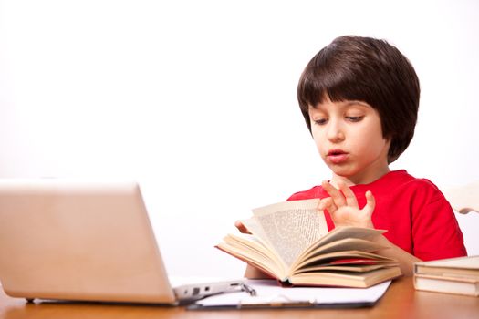 little boy in red t-shirt with computer and textbooks on white background