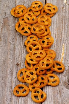Heap of Crunchy Pretzels In a Row closeup on Rustic Wooden background