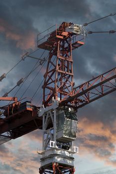 Industrial red crane, sunset background, construction and works