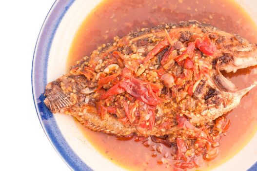 A deep fried fish topped with chili.