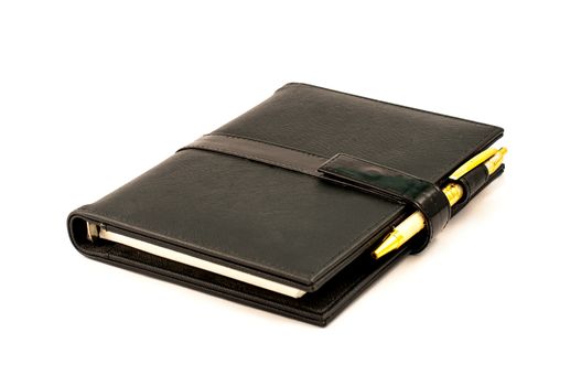Black note book with ballpoint pen on white background