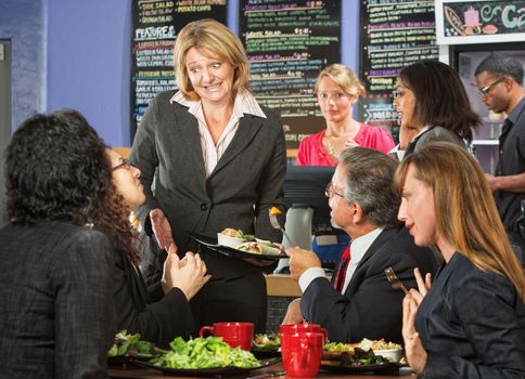 Embarrassed cafe manager with group of unsatisfied customers