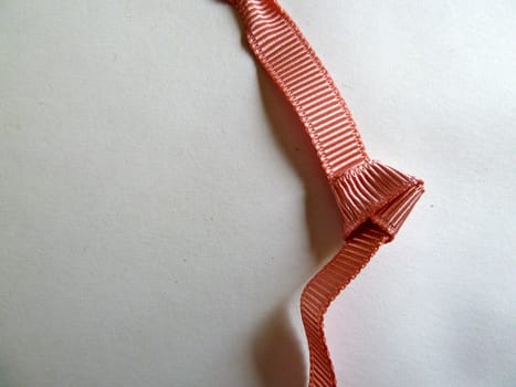 Unusual bright pink knotted ribbon on a white background