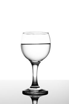 Classy backlit glass of water on white backround and reflection