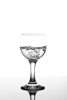 transparent glass with fizzy water on white background