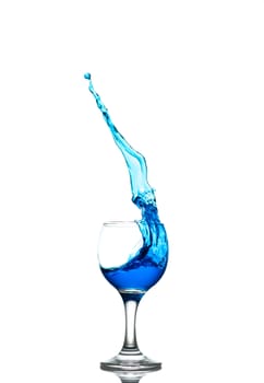 blue drink splashes out of glass on white background
