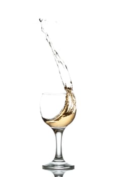 yellow drink splashes out of glass on white background