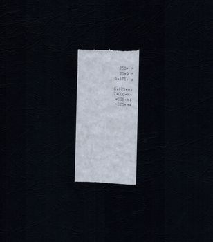 bill or receipt isolated over light black paper background