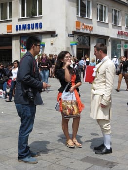 VIENNA, CIRCA JUNE 2013 - Mozart man trying to sell  concert ticket to a couple of Asian tourists in Vienna, June 2013 