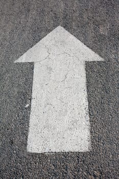 A forwarded big white arrow on the road