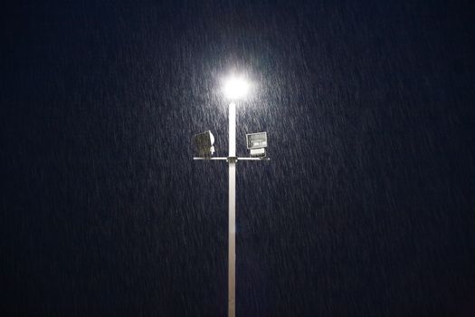 lights on a sports field at evening in the rain