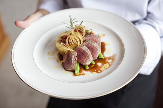 Beef medallions on chef hand