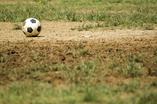 Old Soccer Ball. Poor school soccer field. Charity.